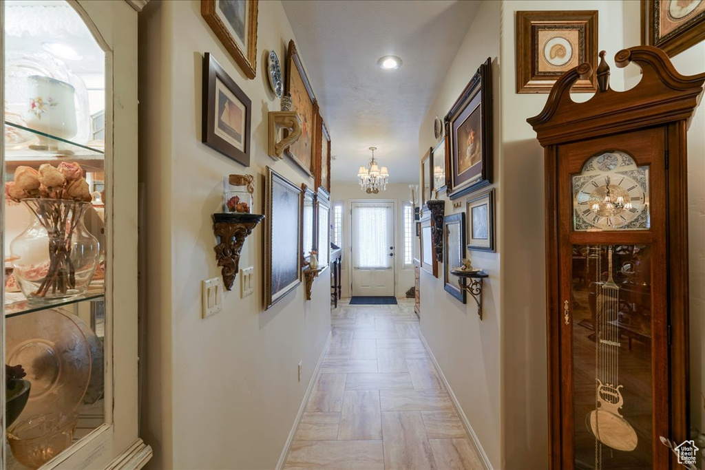 Hall with a chandelier, baseboards, and recessed lighting