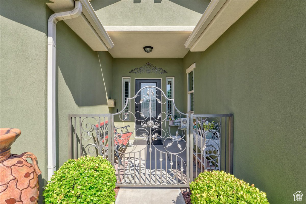 Entrance to property featuring stucco siding and a gate
