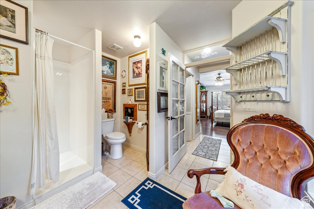 Bathroom with tile patterned flooring, a shower with curtain, ceiling fan, and french doors