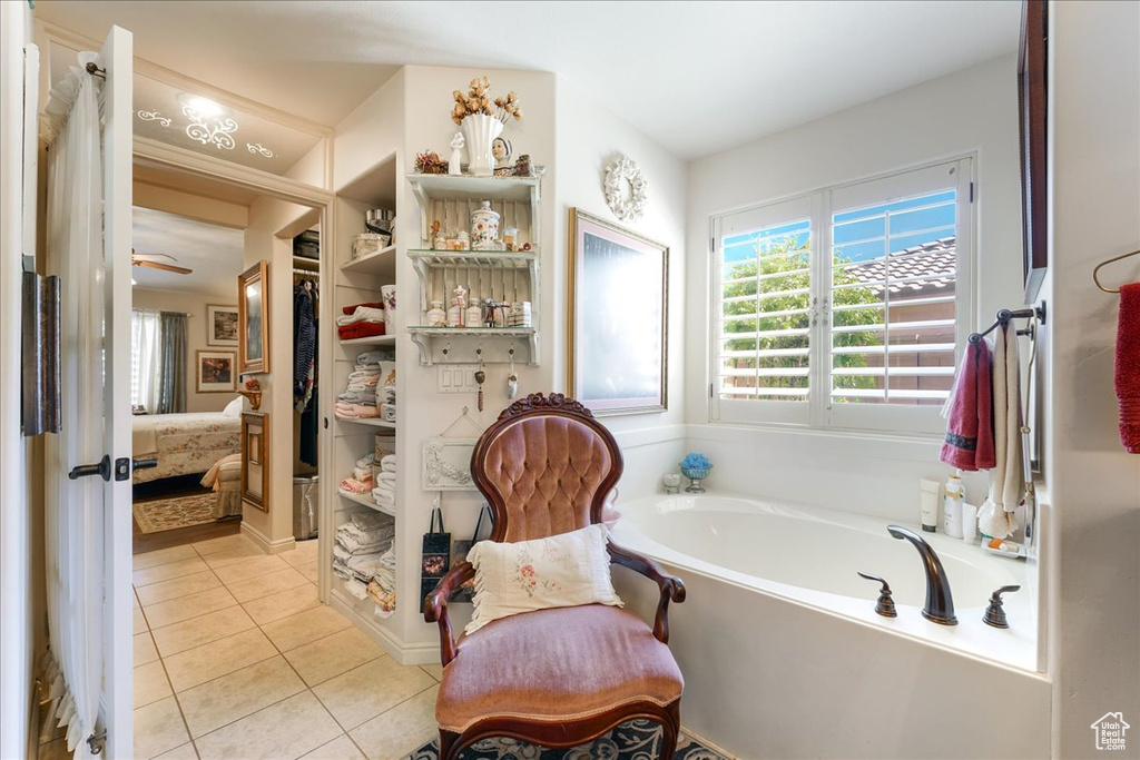 Ensuite bathroom featuring tile patterned floors, plenty of natural light, and a bath