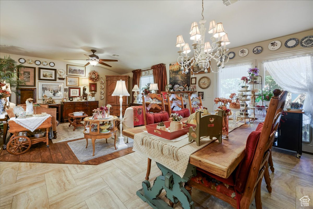 Dining space with plenty of natural light, a chandelier, ceiling fan, and lofted ceiling
