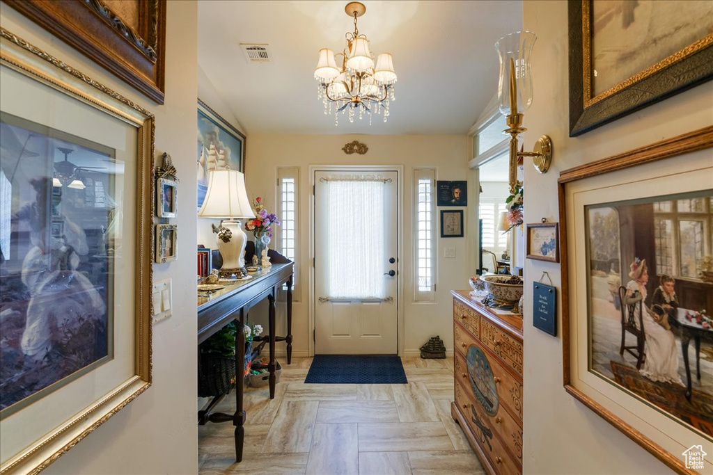 Entryway featuring healthy amount of natural light, a chandelier, and baseboards