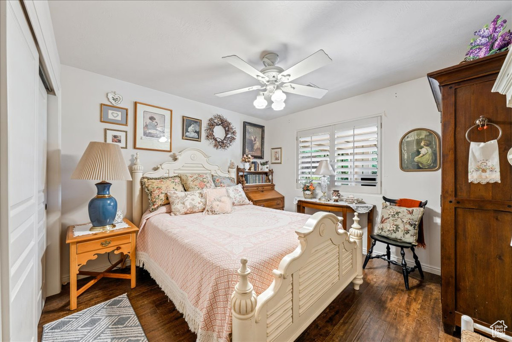 Bedroom with dark wood-style floors, ceiling fan, and a closet
