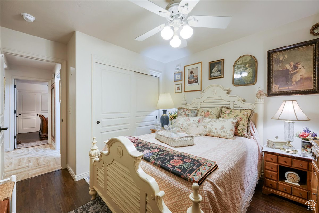 Bedroom with wood finished floors, a closet, a ceiling fan, and baseboards