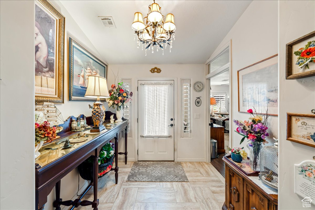 Entryway featuring a chandelier and baseboards