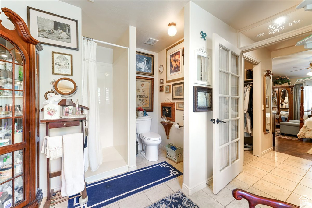 Bathroom with tile patterned floors, a shower with curtain, french doors, and a ceiling fan