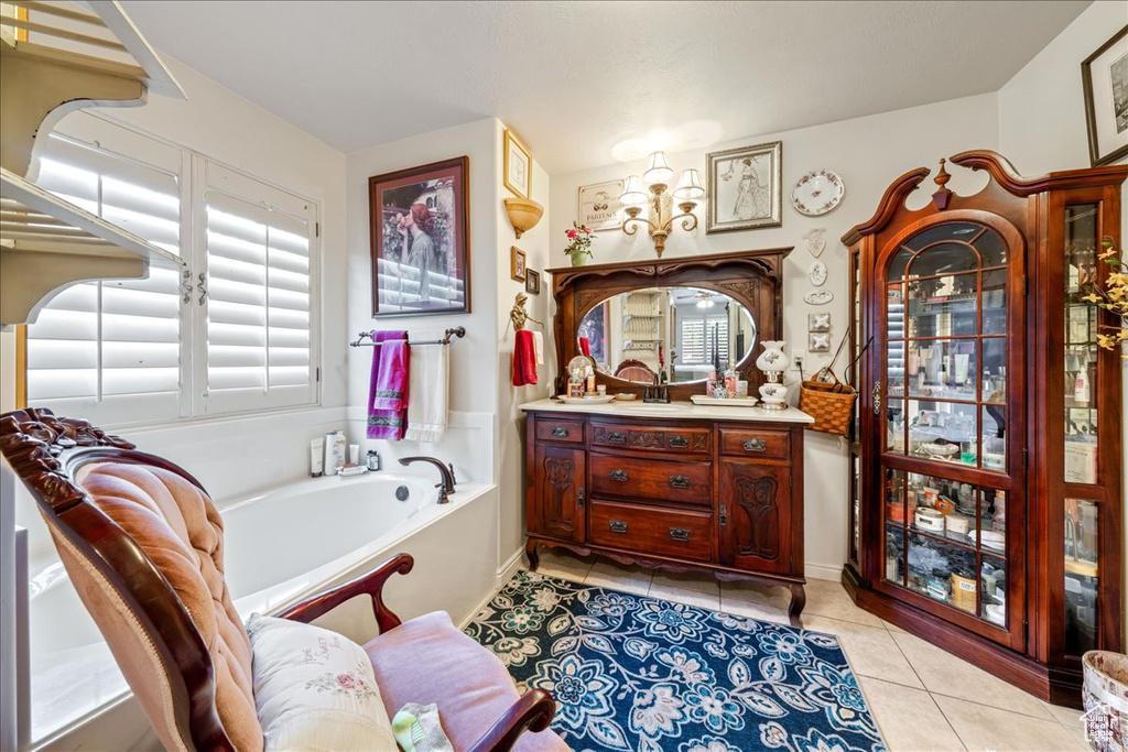 Bathroom featuring vanity, a bath, and tile patterned flooring