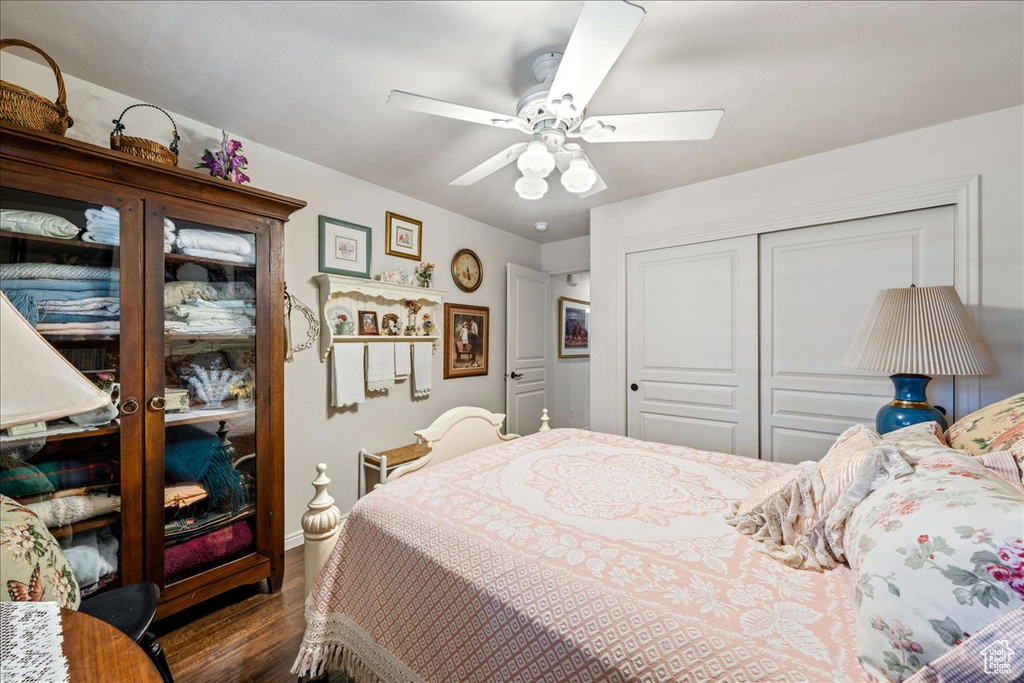 Bedroom with dark wood finished floors, a closet, and a ceiling fan