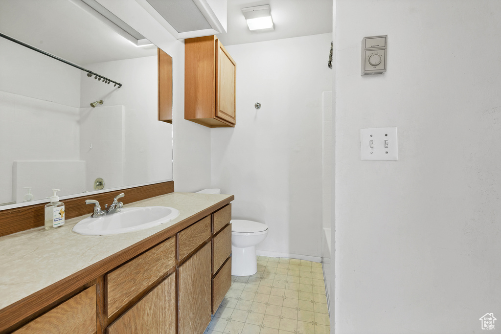 Full bath with vanity, toilet, and tile patterned floors