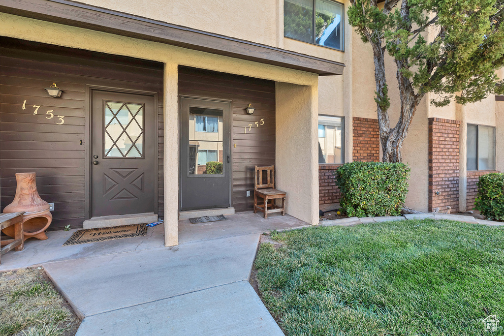 View of exterior entry with stucco siding and brick siding
