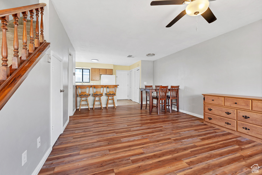 Living area with light wood-type flooring, ceiling fan, and baseboards