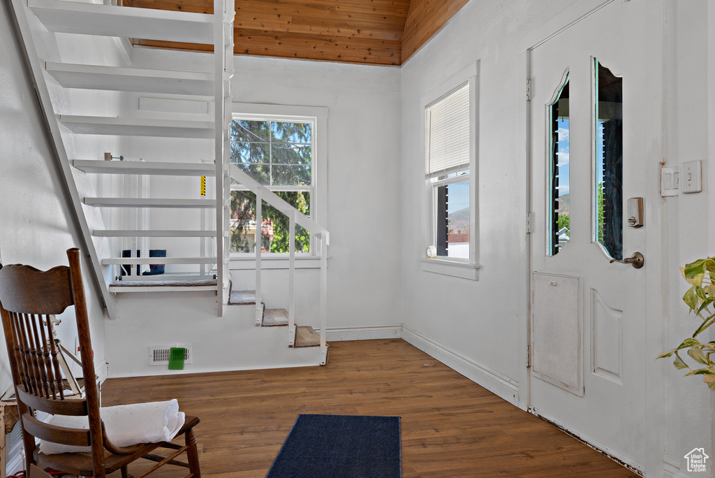 Foyer entrance with wood finished floors, baseboards, and stairs