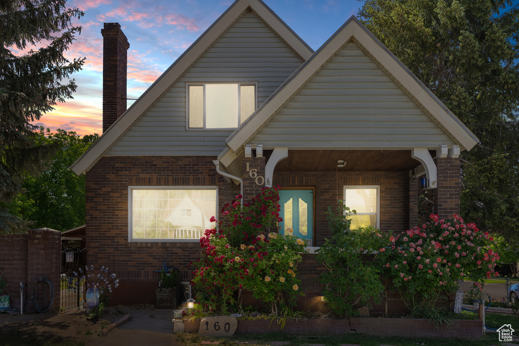 View of front of house with brick siding and a chimney