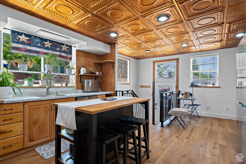 Kitchen featuring wood counters, an ornate ceiling, a sink, light wood-type flooring, and open shelves