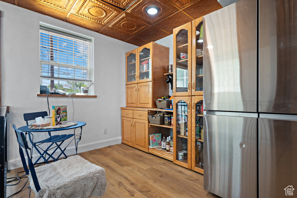 Living area featuring an ornate ceiling, baseboards, and light wood-style flooring