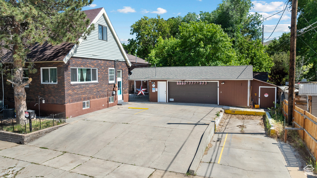 View of front of home with brick siding, an attached garage, and concrete driveway