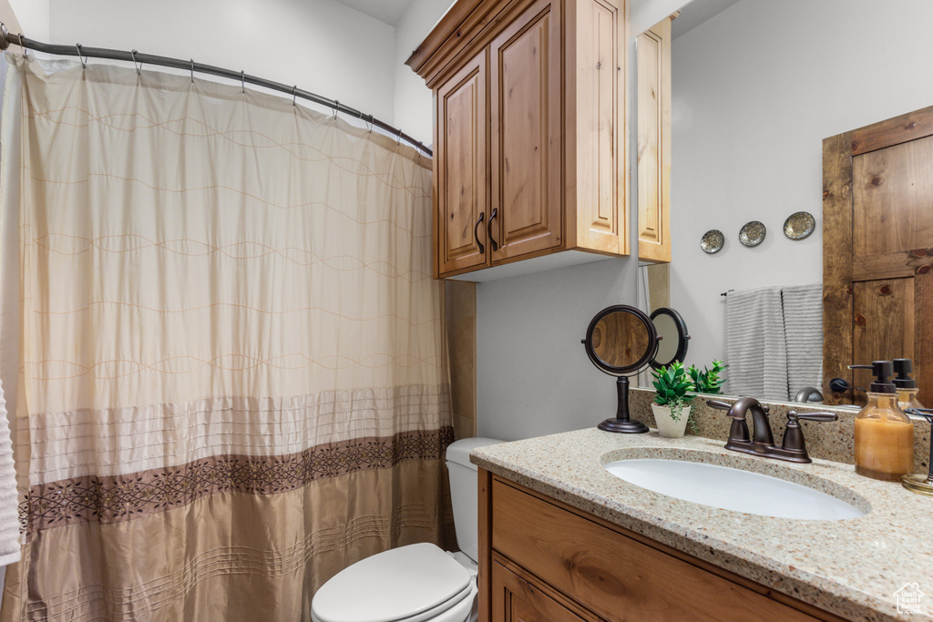 Bathroom featuring vanity, toilet, and a shower with curtain