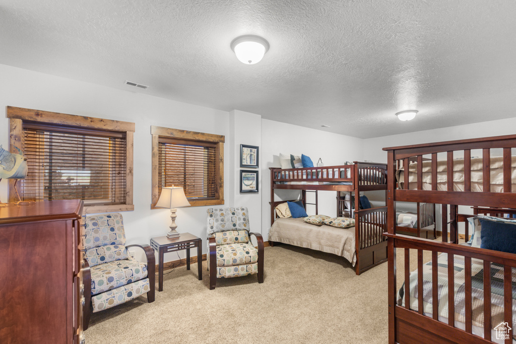 Bedroom with a textured ceiling, carpet floors, and baseboards
