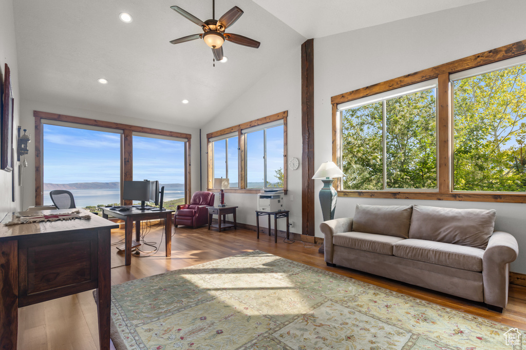 Living room with lofted ceiling, ceiling fan, wood finished floors, and recessed lighting