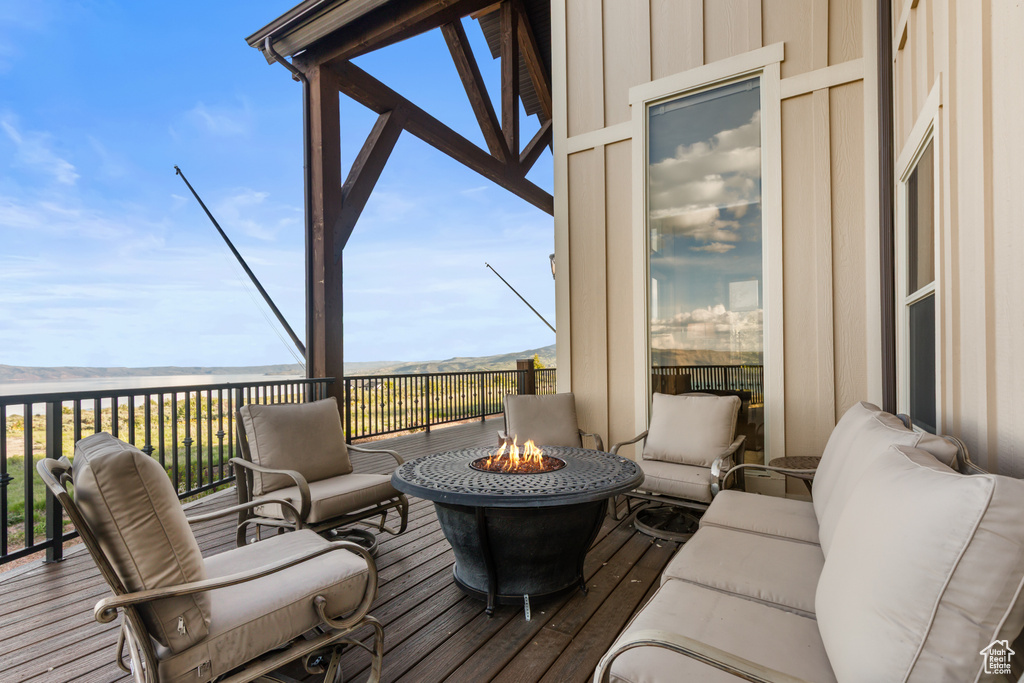 Wooden deck featuring an outdoor living space with a fire pit and a mountain view