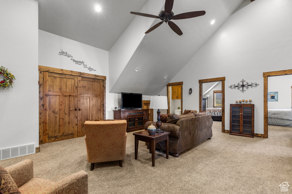 Living area featuring light carpet, high vaulted ceiling, a ceiling fan, and recessed lighting
