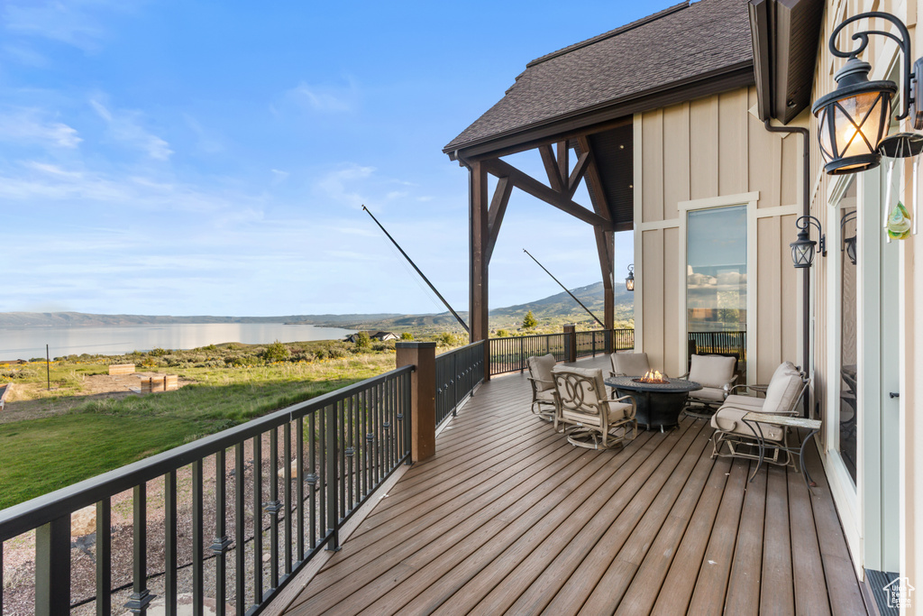 Deck with an outdoor fire pit and a water view