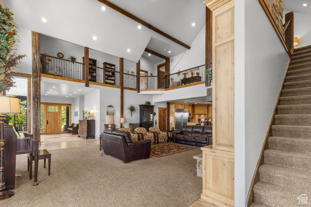 Living room featuring high vaulted ceiling, stairway, carpet, recessed lighting, and beamed ceiling