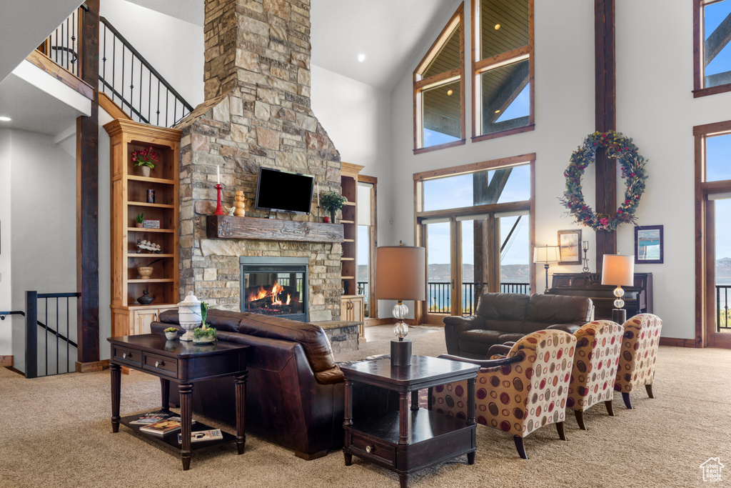 Carpeted living area with a high ceiling, a fireplace, and baseboards