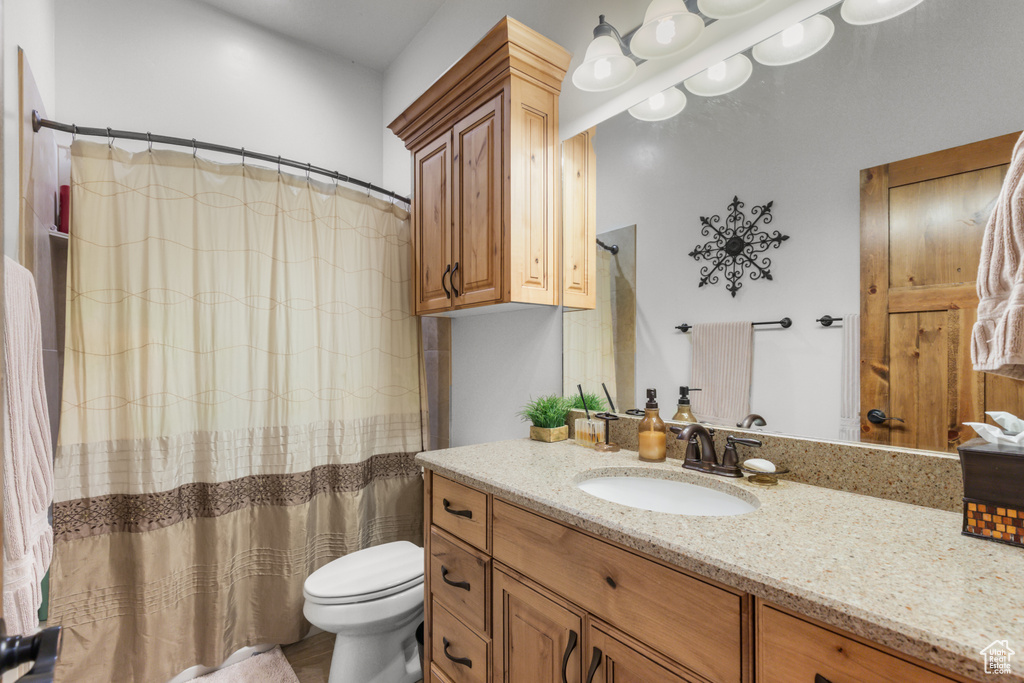Bathroom featuring vanity, toilet, and a shower with curtain