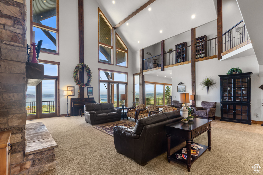 Carpeted living room with high vaulted ceiling, beamed ceiling, and recessed lighting