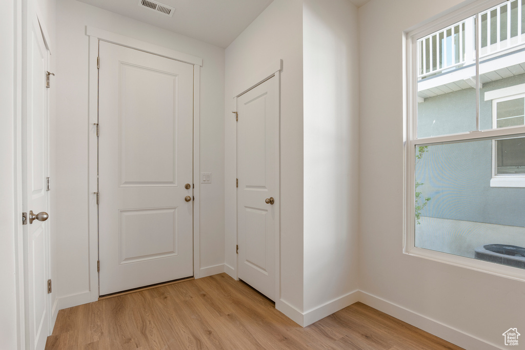 Doorway with light wood-style floors and baseboards