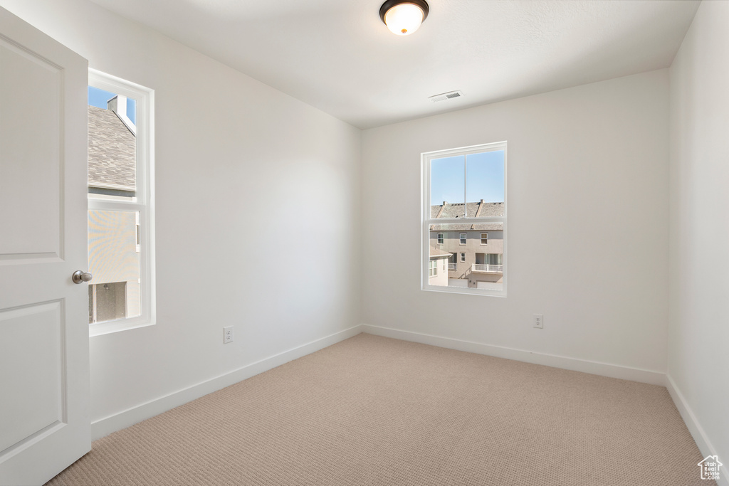 Unfurnished room featuring light colored carpet and baseboards