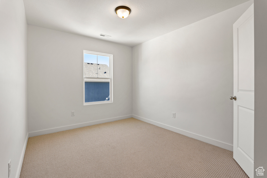 Unfurnished room with light carpet and baseboards