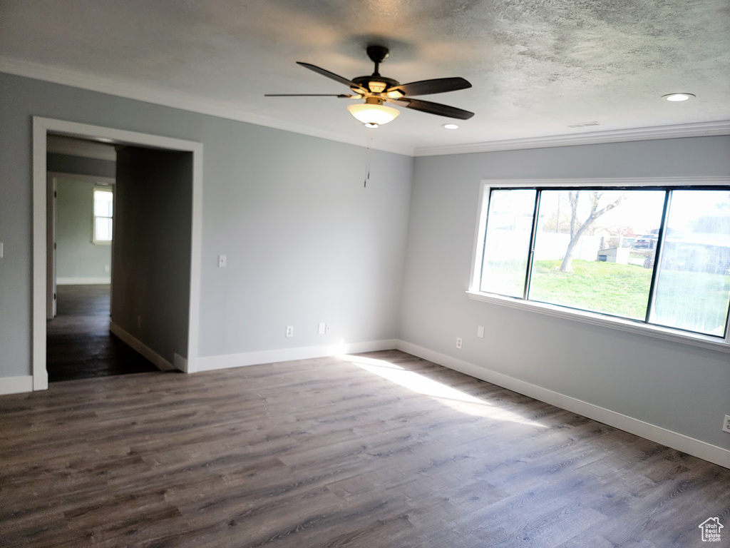 Spare room featuring a ceiling fan, dark wood-style flooring, baseboards, ornamental molding, and recessed lighting