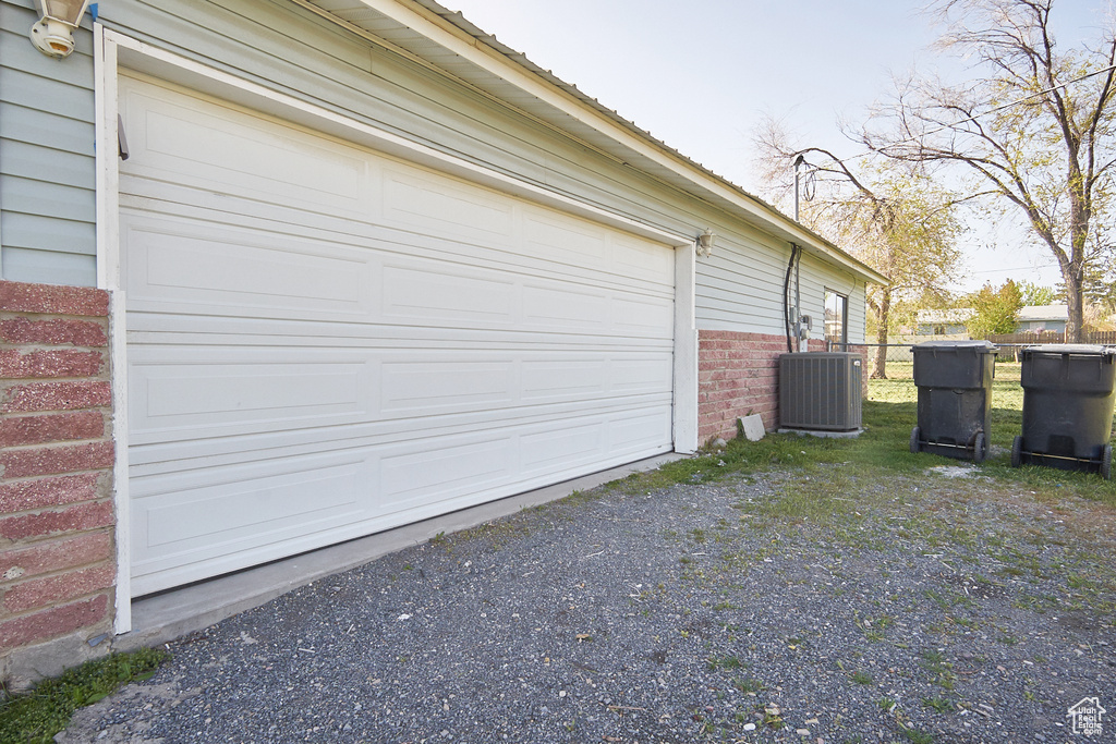 Garage with central air condition unit and driveway