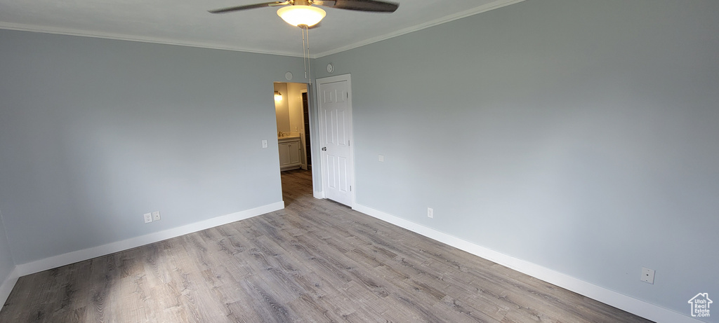 Spare room with ceiling fan, baseboards, wood finished floors, and ornamental molding
