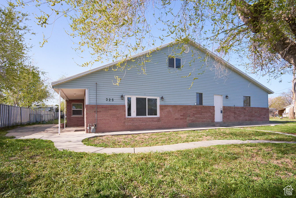 Back of property with brick siding and a patio