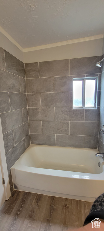 Full bath featuring wood finished floors,  shower combination, and crown molding