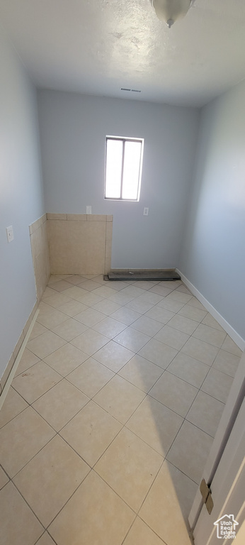 Spare room with baseboards and light tile patterned floors