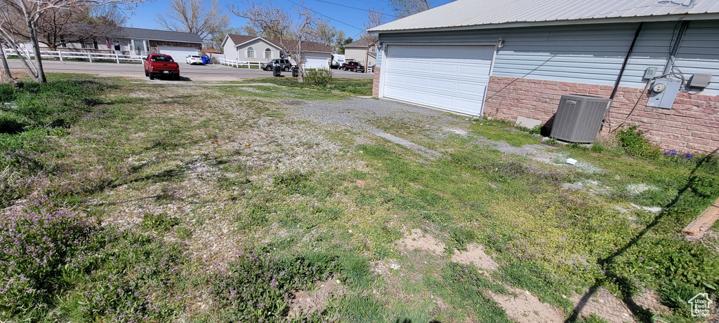View of yard featuring central air condition unit and a garage
