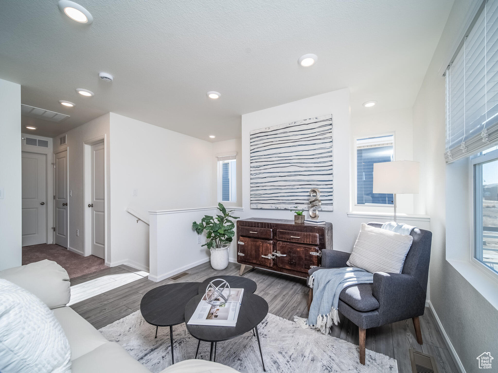 Living area with wood finished floors and recessed lighting