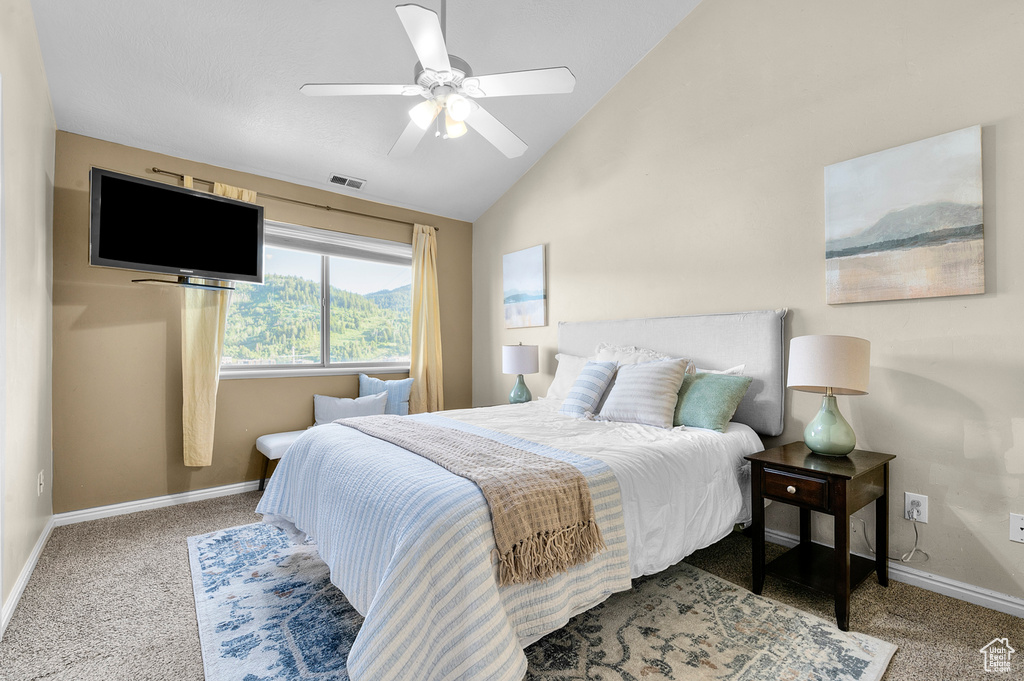 Bedroom with lofted ceiling, baseboards, carpet flooring, and a ceiling fan