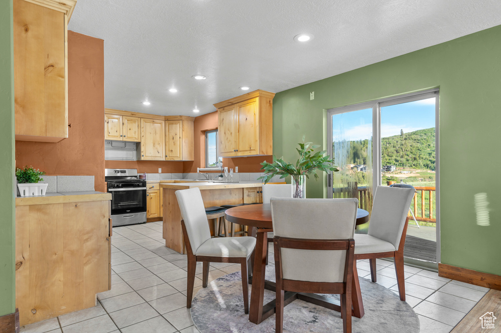 Dining room featuring healthy amount of natural light, recessed lighting, and light tile patterned floors