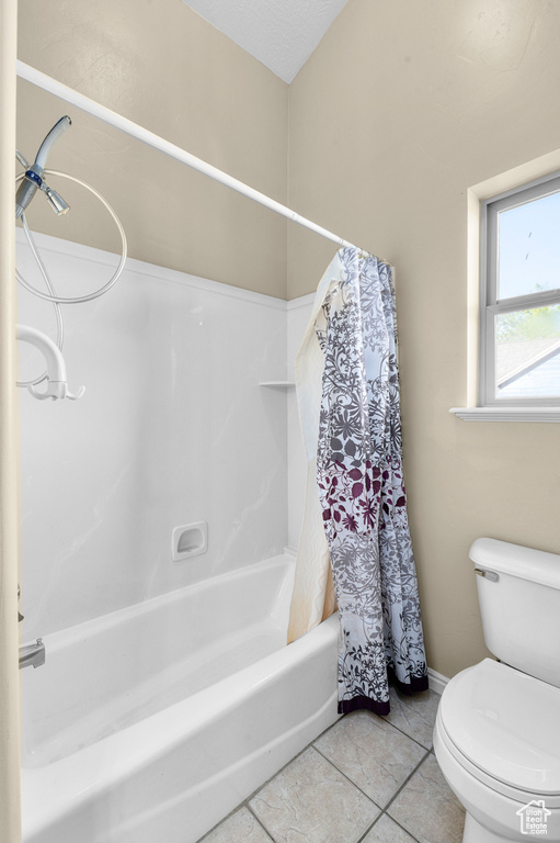 Full bath featuring shower / bath combination with curtain, toilet, and tile patterned floors