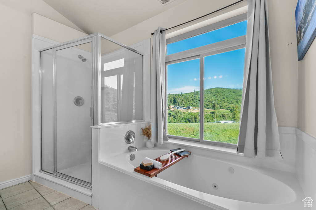 Bathroom with a tub with jets, a shower stall, tile patterned floors, and vaulted ceiling