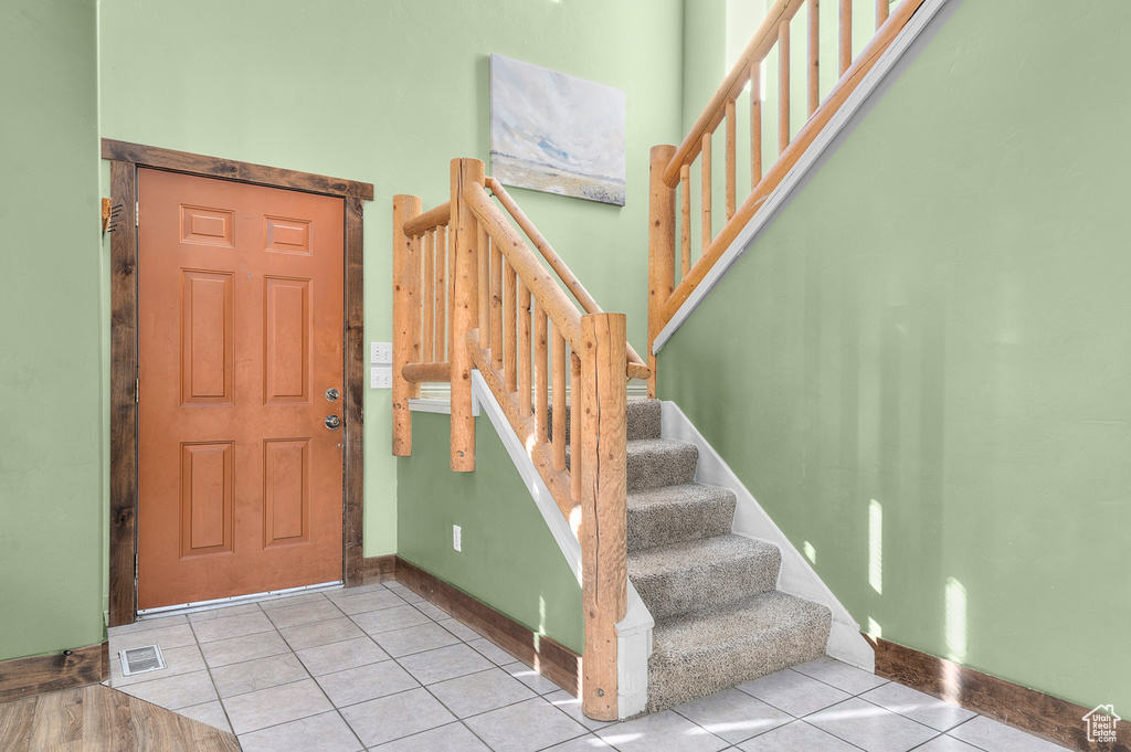 Entrance foyer featuring tile patterned flooring, stairway, and baseboards