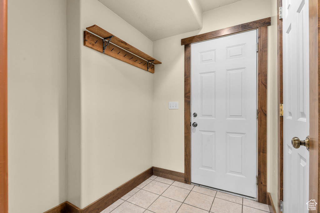 Laundry area with light tile patterned floors and baseboards