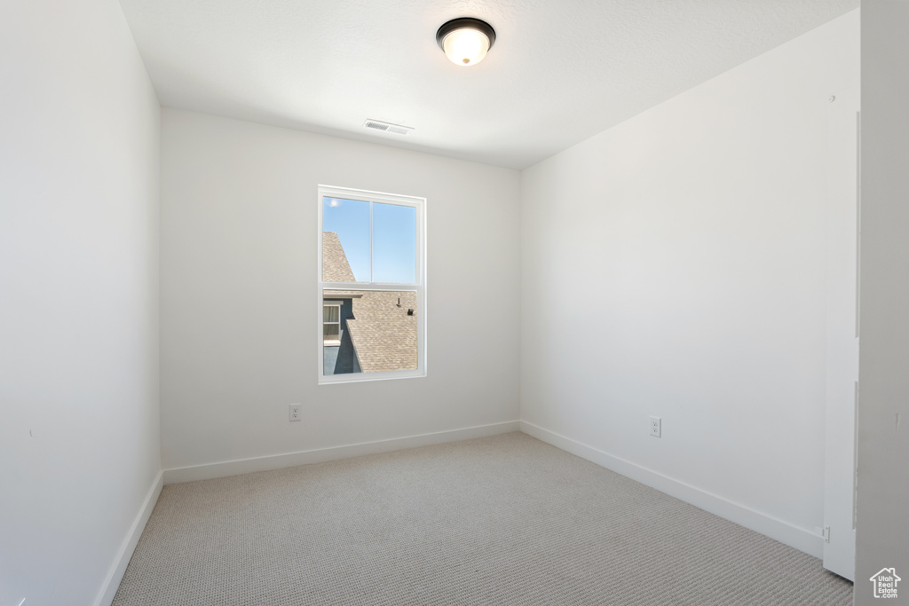 Carpeted spare room with baseboards