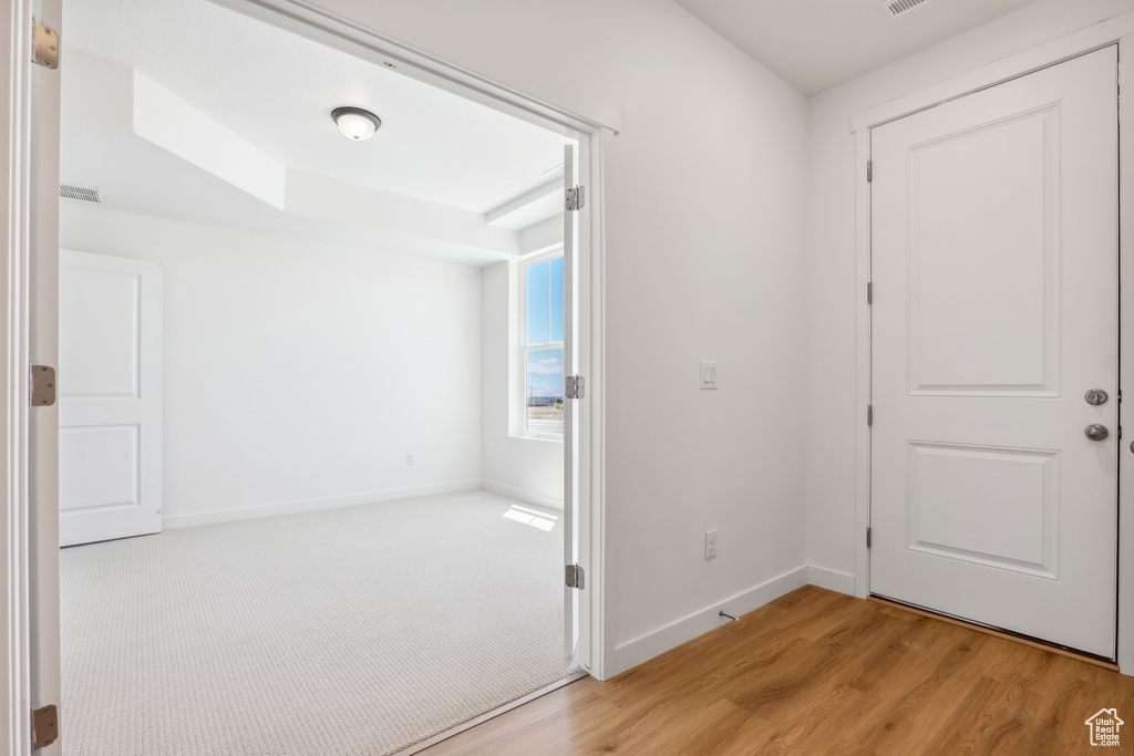 Foyer entrance with light wood finished floors and baseboards