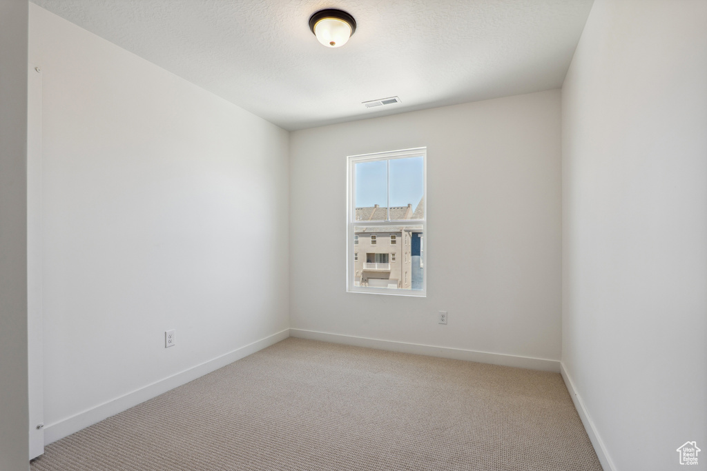 Spare room with light carpet and baseboards